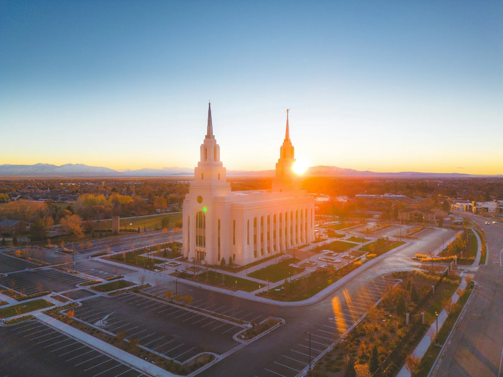 An aerial view of a church with a sunset in the background